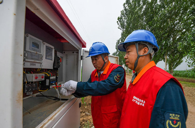 7月6日，國家電網(wǎng)蒙東電力（科右前旗）科爾沁鎮(zhèn)供電所共產(chǎn)黨員服務(wù)隊隊員在檢查農(nóng)田機井的供電情況。新華社記者 彭源 攝