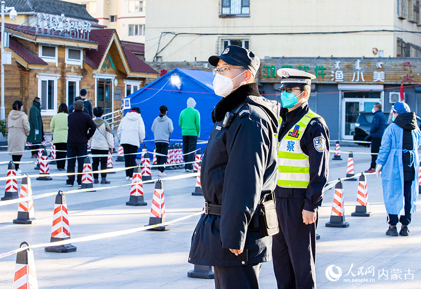 民警在呼和浩特市玉泉區(qū)一處核酸篩查點維持秩序。丁根厚攝