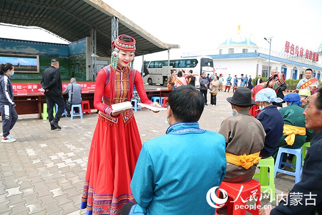 鄂爾多斯烏蘭木騎隊員在母親節(jié)為烏審旗黃陶勒蓋嘎查村民分發(fā)法治宣傳手冊。鄂爾多斯市烏蘭牧騎供圖